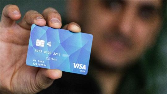 Ein Geflüchteter mit einer Debitcard.