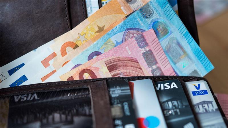 Adieu, Klimpergeld? Diese Karte regiert das Portemonnaie Ein Geldbeutel mit Scheinen und Karten.
