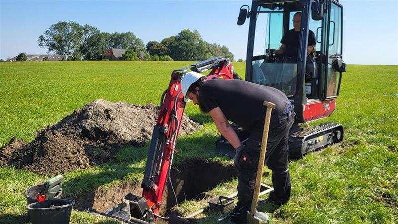 Ein Grabungstechniker gräbt ein Loch, damit die Forschenden mehr über die frühe Besiedlung in Butjadingen erfahren. 