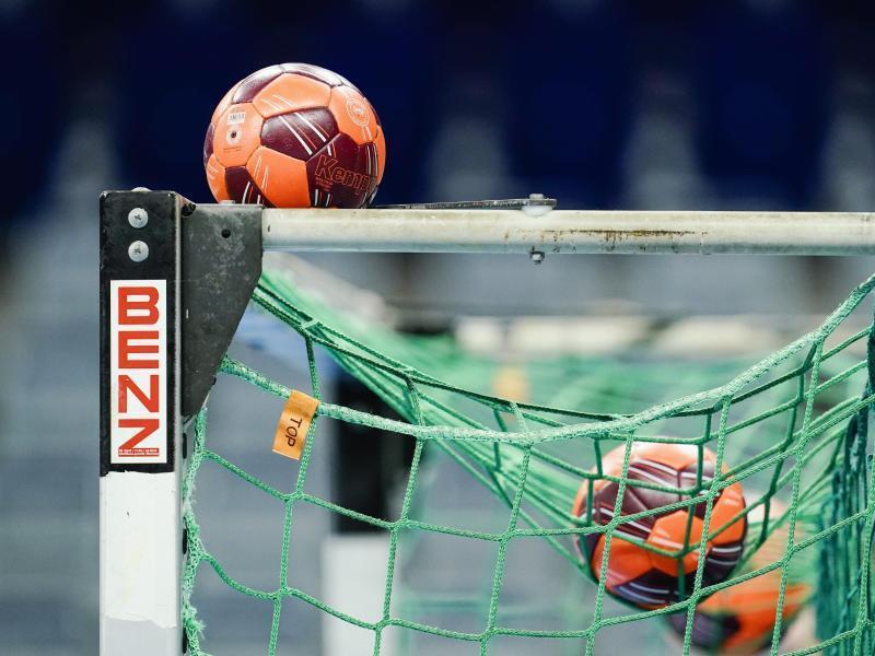 Ein Handball liegt auf dem Netz eines Tors. Foto: Uwe Anspach/dpa/Symbolbild