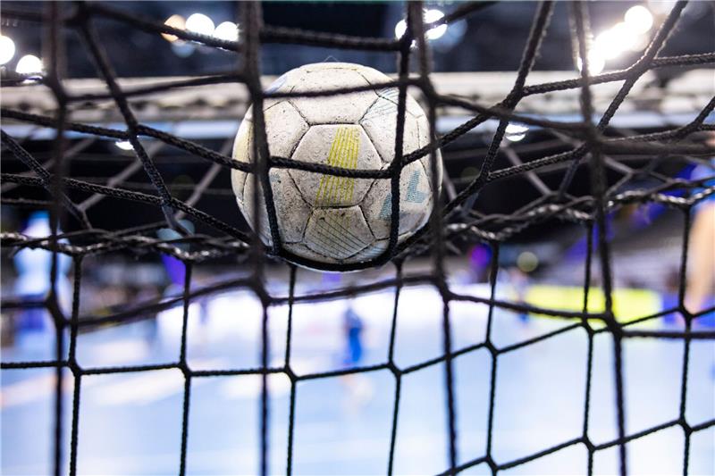 Ein Handball liegt auf einem Tornetz.