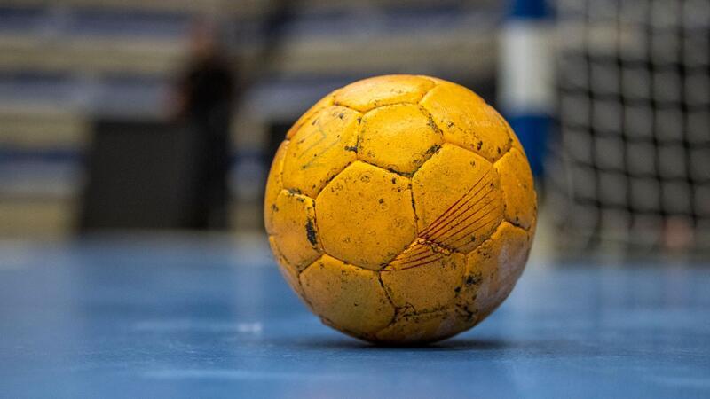 Ein Handball liegt vor einem Tor.