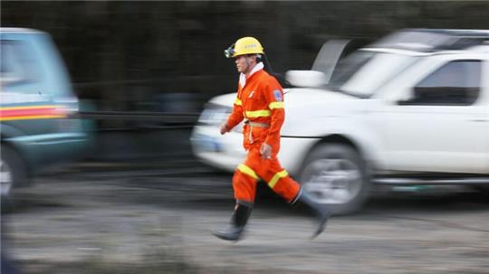 Ein Helfer eines Rettungsdienstes läuft bei einem Einsatz nach einem Grubenunglück.