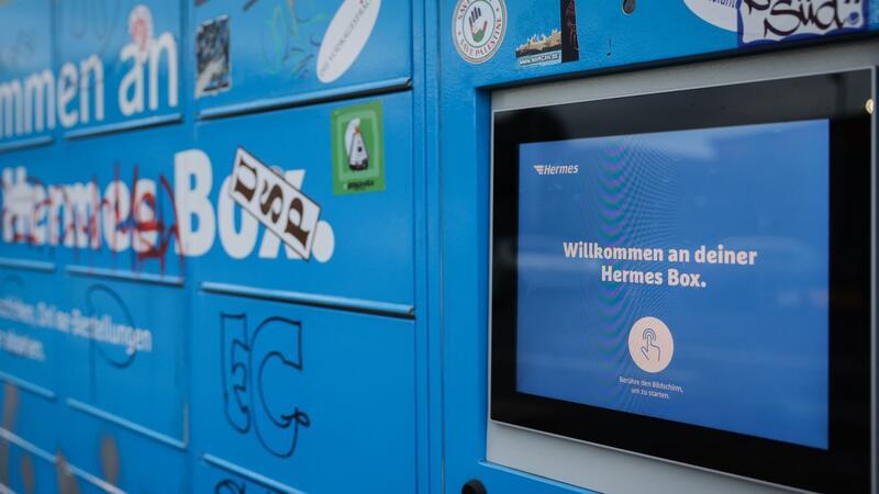 Ein Hermes-Paketautomat steht an einem Parkplatz zu einem Einkaufszentrum im Stadtteil St. Pauli.