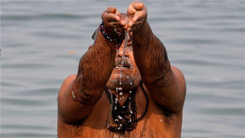Ein Hindu-Pilger verehrt den Sonnengott während eines rituellen Bades im Hooghly-Fluss anlässlich des Makar Sankranti-Festes in Kolkata.