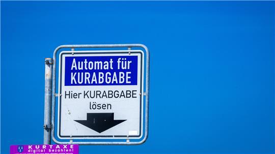 Ein Hinweisschild hängt über dem Zahlautomaten für die Entrichtung der Kurabgabe.