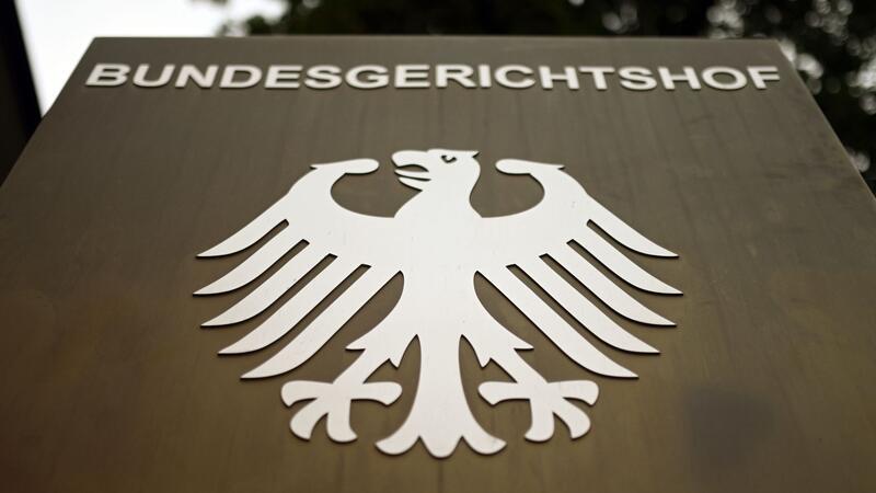 Ein Hinweisschild mit dem Bundesadler steht vor dem Bundesgerichtshof (BGH) in Karlsruhe.