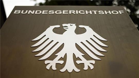 Ein Hinweisschild mit dem Bundesadler steht vor dem Bundesgerichtshof (BGH) in Karlsruhe.