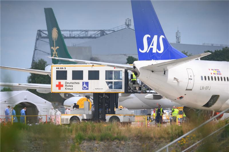 Ein Hubliftfahrzeug des DRK (Deutsches Rotes Kreuz) steht während des Entladens der Patienten auf dem Vorfeld an dem SAS-Flugzeug.  Foto: Jonas Walzberg/dpa