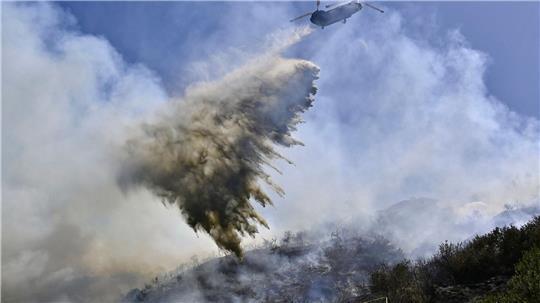 Ein Hubschrauber bekämpft Waldbrände in Kalifornien.