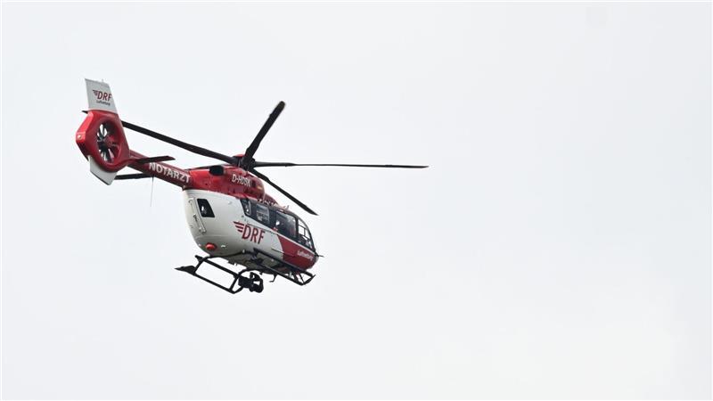 Ein Hubschrauber der Deutschen Luftrettung fliegt bei einem Rettungseinsatz.
