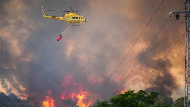 Ein Hubschrauber ist bei einem Waldbrand in Spanien am Odiel-Fluss in der Gemeinde Gibraleón im Einsatz.