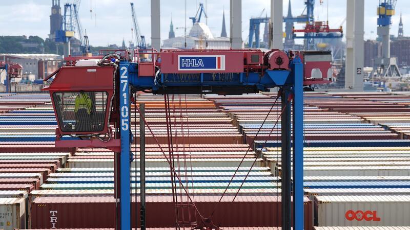 Hafenarbeiter sollen mehr Geld bekommen - keine Warnstreiks Ein Hubwagen fährt zwischen Containern im Hamburger Hafen umher. (Archivbild)