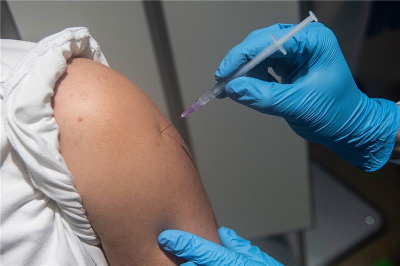 Ein Impfwilliger wird im Impfzentrum am ehemaligen Flughafen Tegel geimpft. Nun liegt wohl ein erster Entwurf zur Impfpflicht vor. Foto: Paul Zinken/dpa