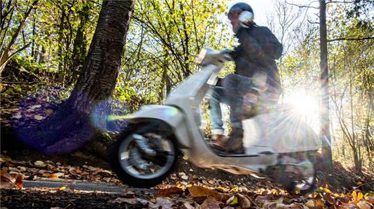 Ein Mann fährt auf einem Motorroller.