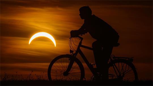 Ein Junge auf einem Fahrrad betrachtet die partielle Sonnenfinsternis in Jacobsdorf, im östlichen Brandenburg.