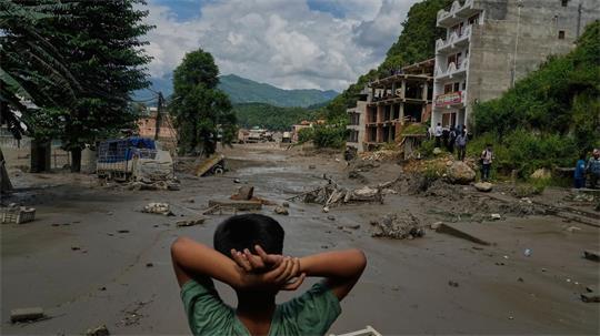 Ein Junge betrachtet die Verwüstungen durch die Sturzflut in Nepal. (Archivbild)