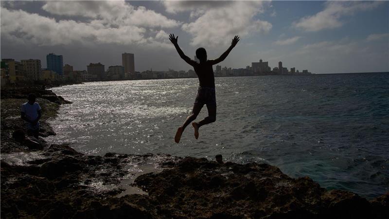 Ein Junge springt ins Meer, auch wenn der Strom in Land ausgefallen ist.