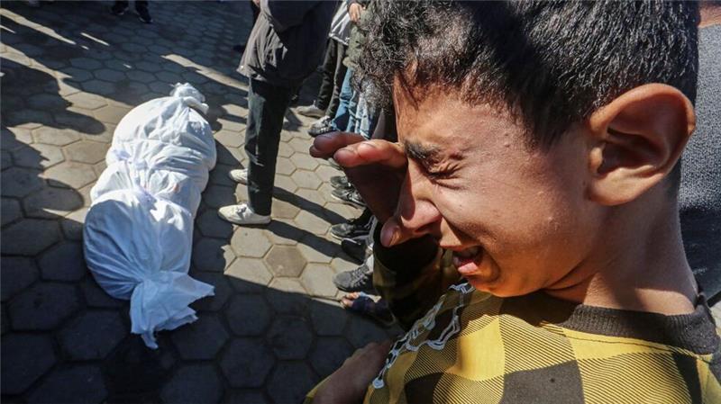 Ein Junge weint neben einem der Toten des israelischen Angriffs auf Deir al-Balah 