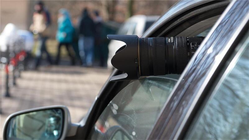 Lohnbetrug: Privatdetektiv überführt krankgeschriebenen Koch Ein Kameraobjektiv schaut aus einem Autofenster heraus. Allerdings hat der Gesetzgeber der Überwachung von Personen enge Grenzen gesetzt.
