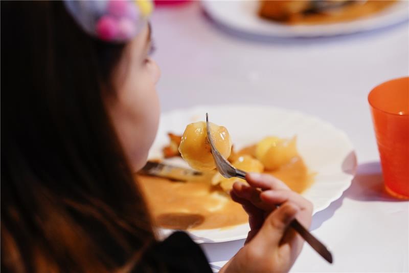 Ein Kind bekommt in einer Jugendkirche ein warmes Mittagessen, was es zu Hause nicht bekommen hätte. Foto: Uwe Anspach/dpa