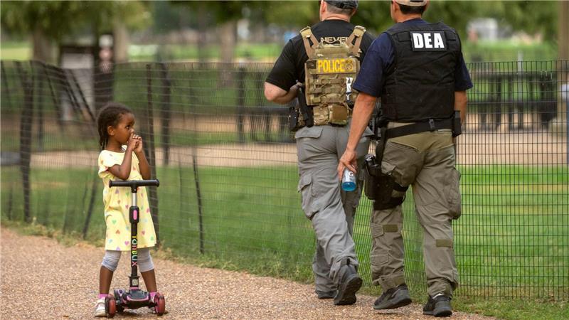 Bilder des Tages Ein Kind beobachtet, wie Beamte der Drug Enforcement Administration entlang der National Mall in Washington patrouillieren.