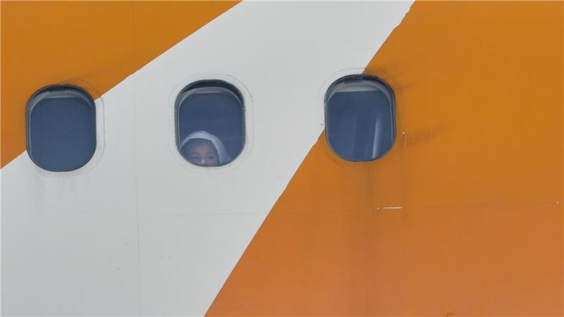 Ein Kind blickt aus einem von Venezuela betriebenen Flugzeug, das mit abgeschobenen Migranten aus den USA auf dem Flughafen Simon Bolivar International in Maiquetia ankommt.