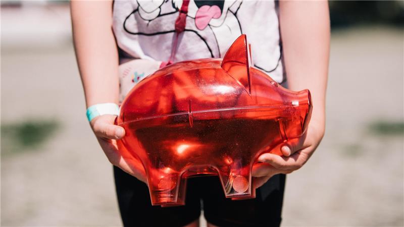 Weltspartag: Deutsche sparen viel – aber oft auch falsch Ein Kind hält ein Sparschwein in den Händen. Foto: Zacharie Scheurer