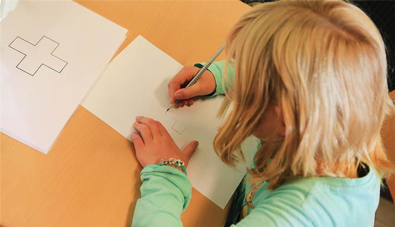 Bereit für die Schule? Kreis-Gesundheitsamt untersucht 2800 Kinder Ein Kind zeichnet ein auf einem Zettel abgebildetes Kreuz ab. Im Rahmen der Schuleingangsuntersuchungen stellt das Kreis-Gesundheitsamt fest, ob ein Kind bereit für die Schule ist. Foto: picture alliance/dpa