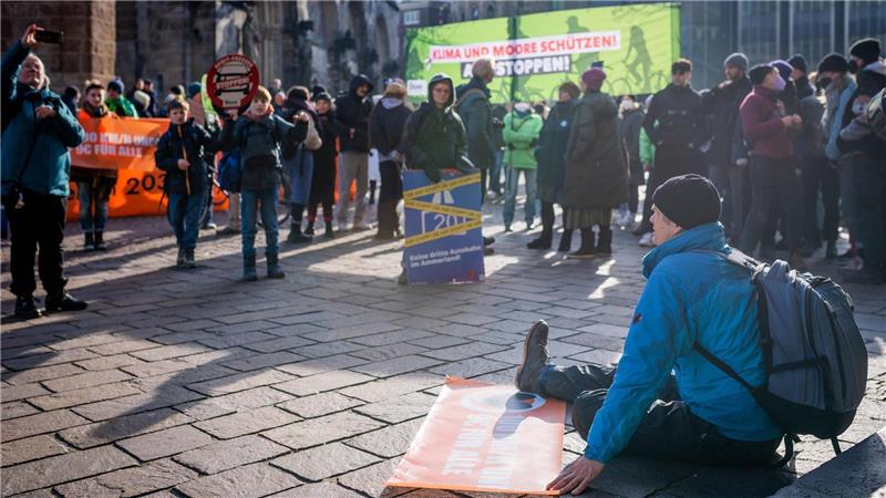 Bremer Schaffermahlzeit mit Protestgetöse und Klebe-Aktivisten Ein Klimaaktivist klebte sich vor dem Rathauseingang auf dem Pflaster fest. Foto: Arnd Hartmann