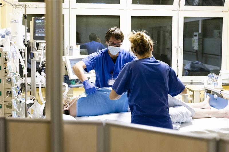 Ein Krankenpfleger und eine Pflegerin kümmern sich um eine Patientin auf der Intensivstation am Universitätsklinikum Schleswig-Holstein.