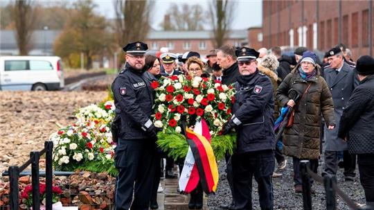 Ein Kranz wird anlässlich des Volkstrauertages auf dem Gelände der KZ-Gedenkstätte Neuengamme getragen.