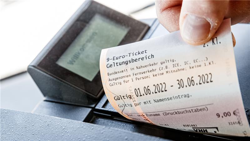 Ein Kunde zieht in einem Bus ein 9-Euro Ticket aus dem Fahrkartendrucker. Foto: Scholz/dpa