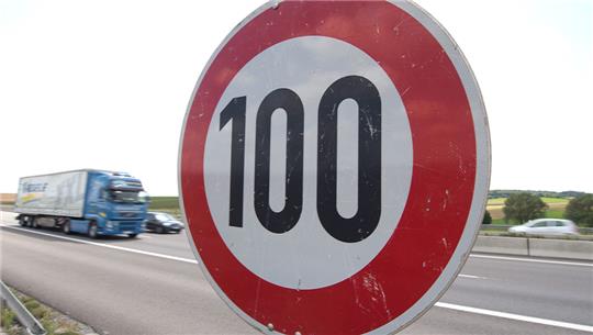 Ein LKW und Autos fahren auf der Autobahn 6 bei Bad Rappenau an einem Tempo-100-Schild vorbei. Foto: Sebastian Kahnert/dpa