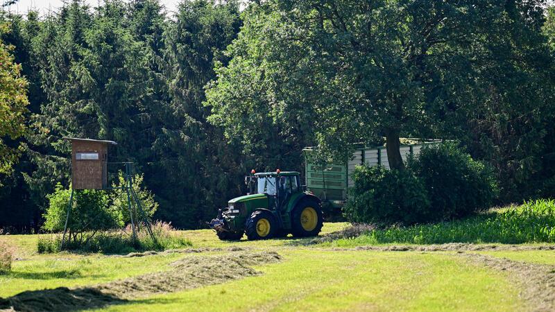 Ein Landwirt fährt mit Traktor über eine Wiese nahe des Fundortes einer Kinderleiche.