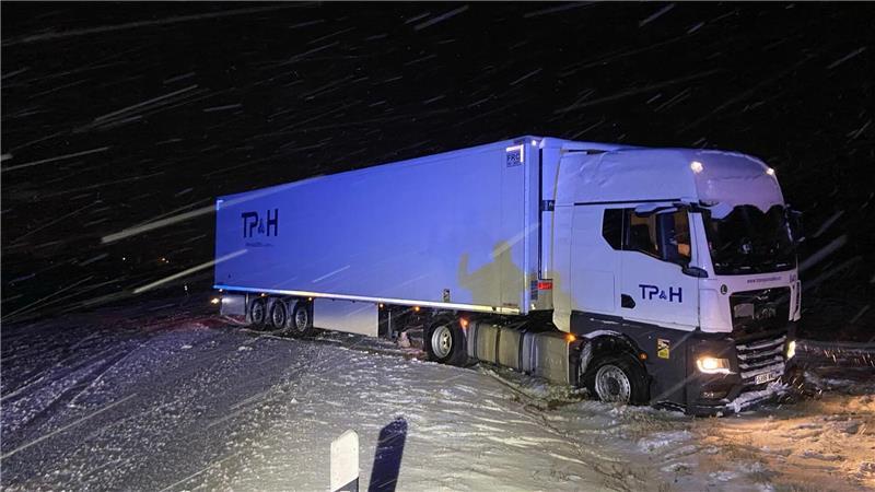 Schnee, Glätte, Brückensperrung – Winter legt Verkehr lahm Ein Lkw ist in Rheinland-Pfalz aufgrund der schneeglatten Fahrbahn ins Rutschen gekommen und hat so den Verkehr blockiert.