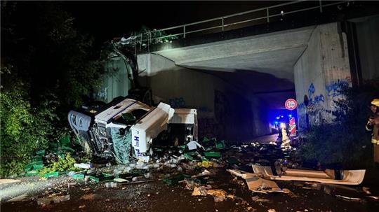 Ein Lkw ist von einer Autobahnbrücke auf eine darunterliegende Straße gestürzt. 