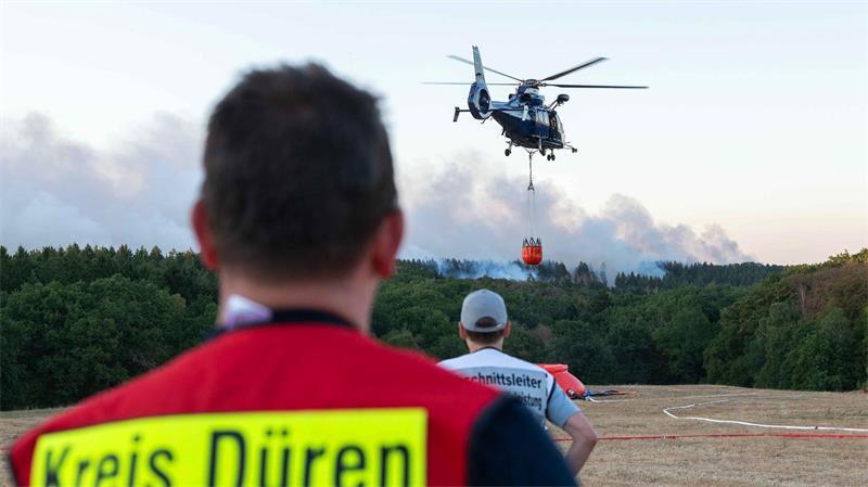 Ein Löschhubschrauber bekämpft am Donnerstagabend die Flammen des Waldbrandes Nahe Hürtgenwald.