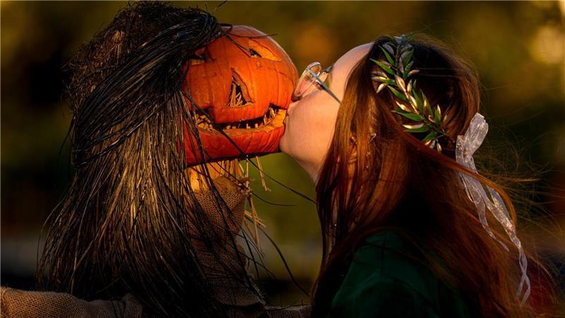 Ein Mädchen posiert für einen Freund und küsst einen Kürbis auf dem West Side Hallo Fest, dem größten Halloween-Festival des Landes, in Bukarest.