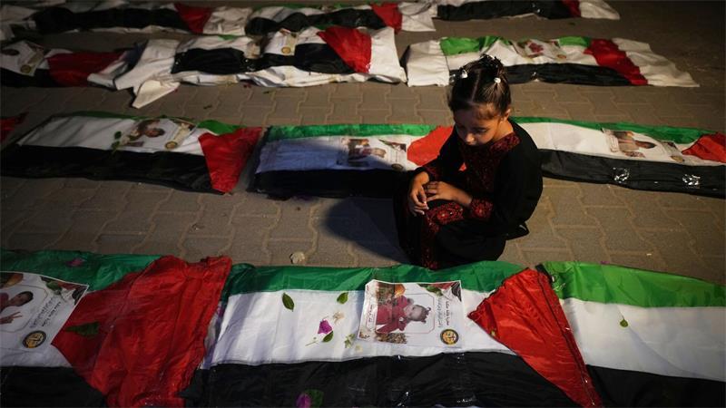 Ein Mädchen sitzt neben den Leichen von Palästinensern an, die aus den Trümmern von Häusern geborgen wurden, die während des Krieges zwischen Israel und der Hamas in Gaza Stadt zerstört worden waren.