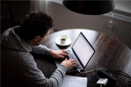Ein Mann arbeitet an seinem Laptop.