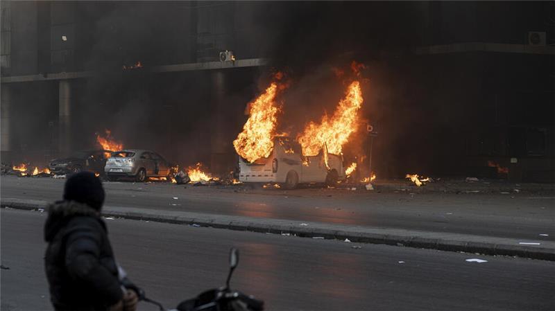 Ein Mann auf einem Motorrad beobachtet, wie in Damaskus nach dem Sturz der Regierung des syrischen Präsidenten Assad Fahrzeuge in Brand gesetzt wurden.