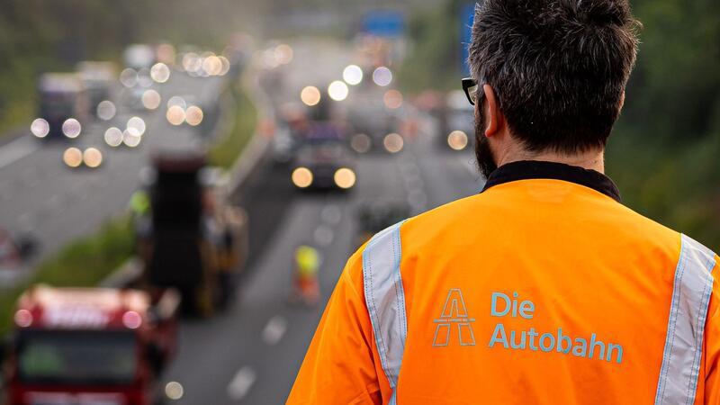 Ein Mann beobachtet Arbeiten auf einer Autobahn.