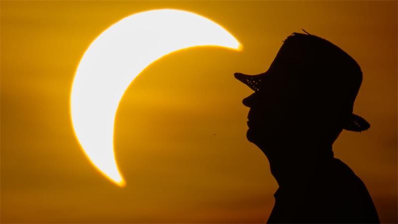 Ein Mann betrachtet die partielle Sonnenfinsternis im östlichen Brandenburg.