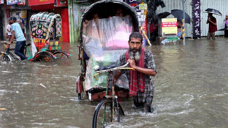Ein Mann bewegt sich nur mühsam mit seiner Rikscha durch die überfluteten Straßen der Stadt Chittagong.