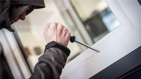 Ein Mann demonstriert in einer polizeilichen Beratungsstelle, wie Einbrecher Fenster aufhebeln.