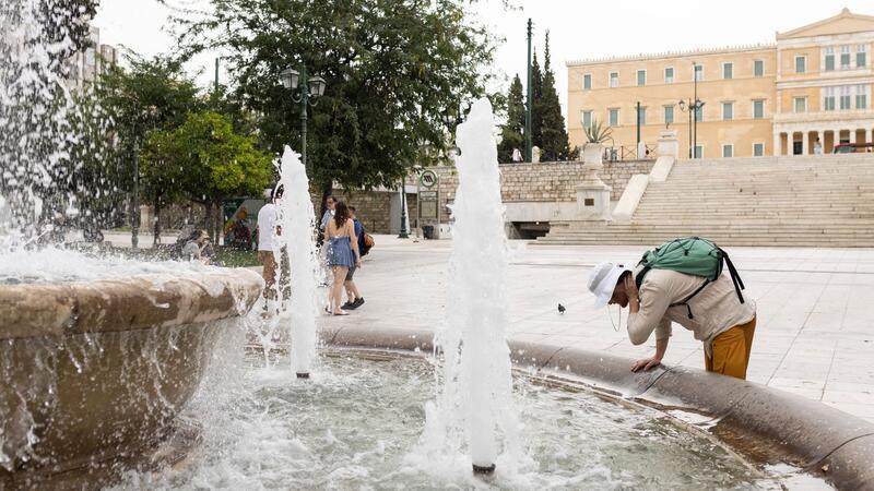 Hitze in der Ägäis erreicht Höhepunkt Ein Mann erfrischt sich an einem Springbrunnen auf dem Athener Syntagma-Platz.