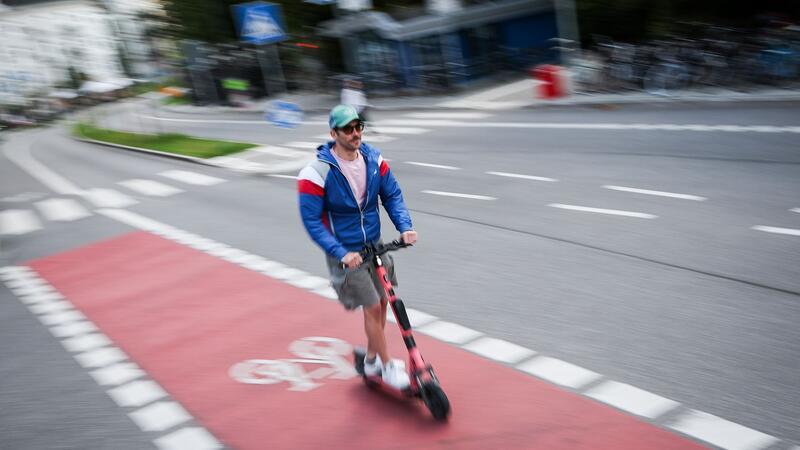 Ein Mann fährt auf einem Radweg in Hamburg mit einem E-Scooter.