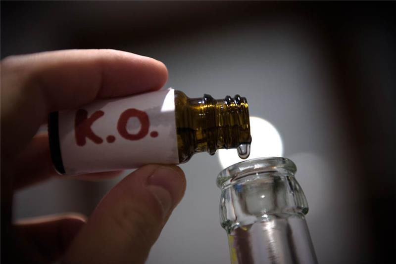 Ein Mann füllt in der gestellten Szene mehrere "K.O. Tropfen" in eine Bierflasche. Foto: Nicolas Armer/dpa