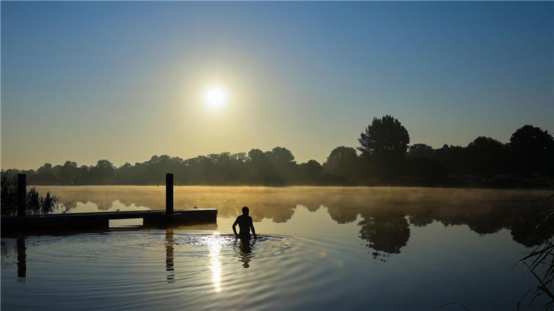 Bilder des Tages Ein Mann geht am frühen Morgen in der Eider schwimmen.